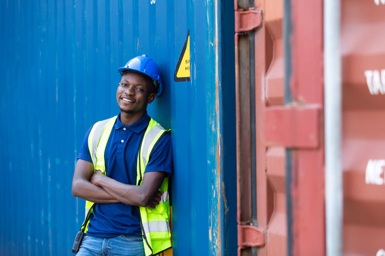 Portrait of a smiling young man leaning at container