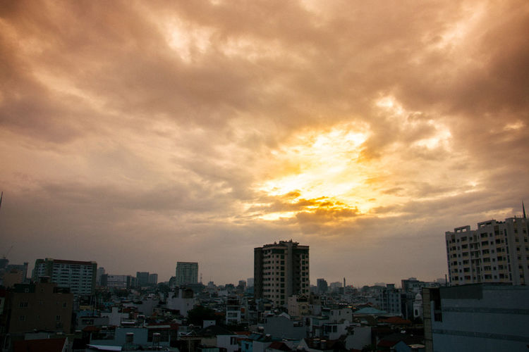 View of city against cloudy sky during sunset