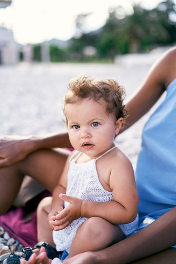 Portrait of cute baby girl sitting outdoors