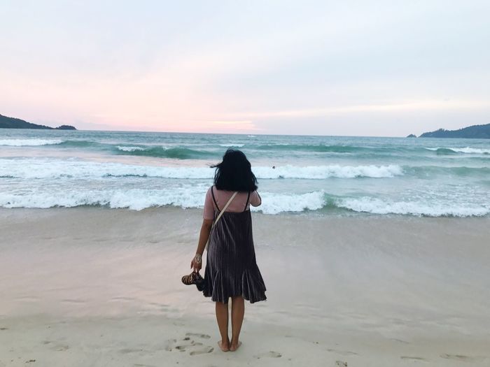 Rear view of woman walking on beach