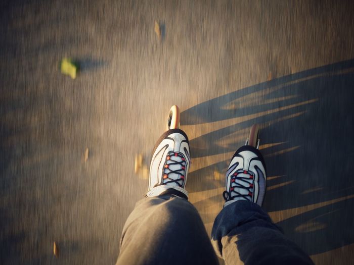 Low section of man inline skating on road