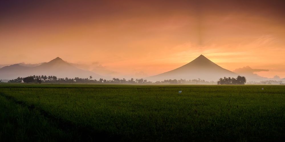 Scenic view of mt mayon against sky during sunrise