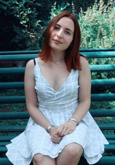 Portrait of beautiful young woman sitting outdoors