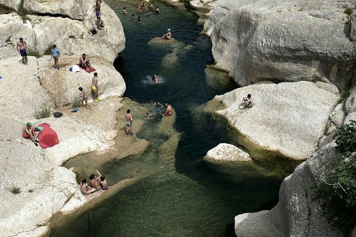 High angle view of people enjoying in river amidst rocks