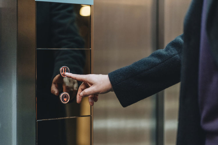Businessman touching lift button at hotel