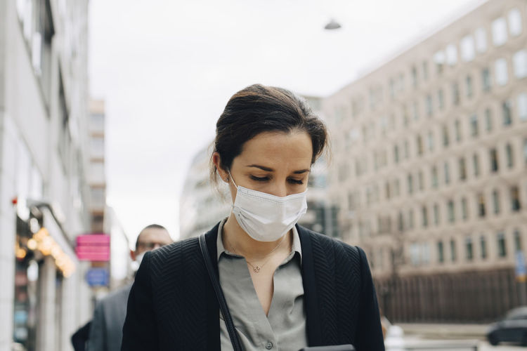 Female entrepreneur with protective face mask in city