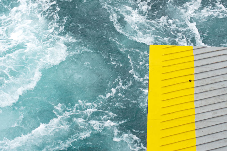 High angle view of yellow sign by sea