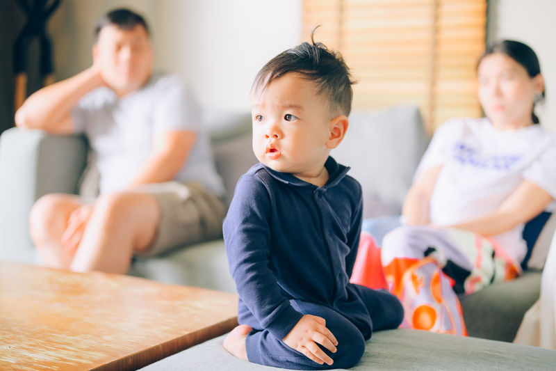Cute boy looking away while sitting at home