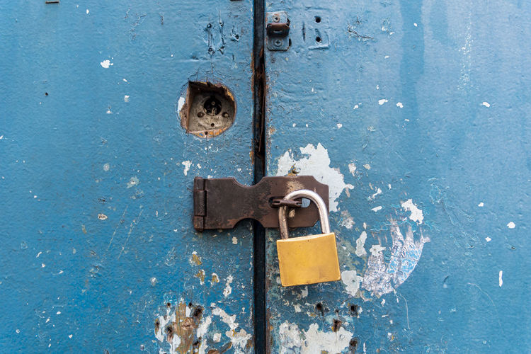 Antique iron padlock closing a wooden door or window in color. pelourinho, salvador, bahia, brazil.
