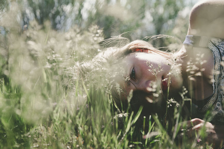 Close-up of a young woman lying in grass