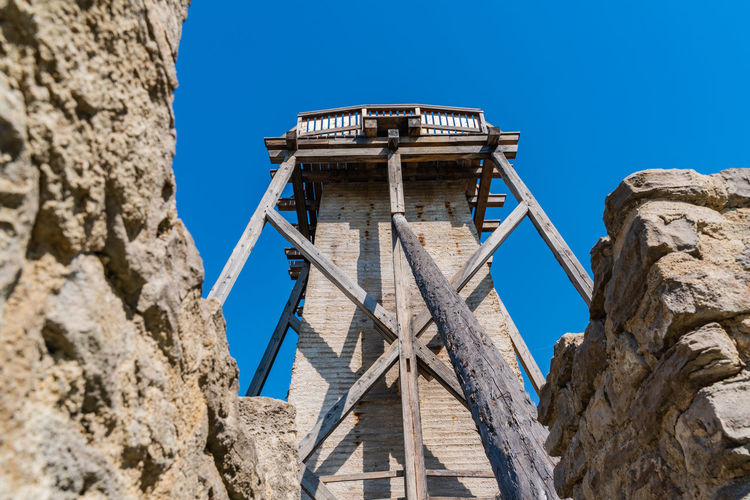 Low angle view of old tower against clear blue sky