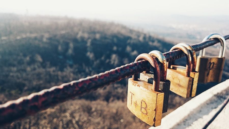 Close-up of padlocks hanging on rusty railing