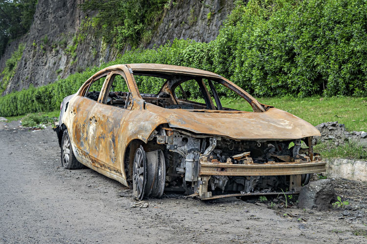 Abandoned burnt car remains on the side of the road