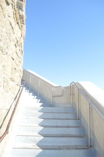 Low angle view of steps leading towards blue sky