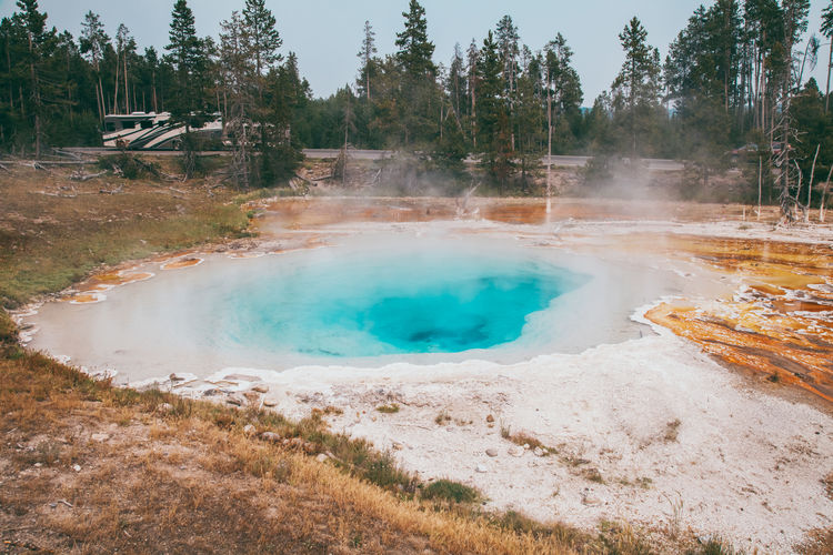 Epic scenic view of colorful steaming pool of geysers in yellowstone national park.