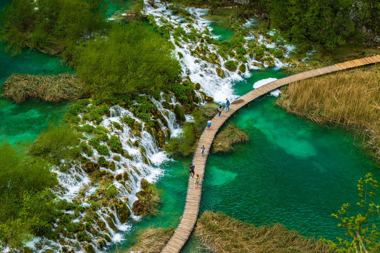 High angle view of people walking on boardwalk over water at plitvice lakes national park