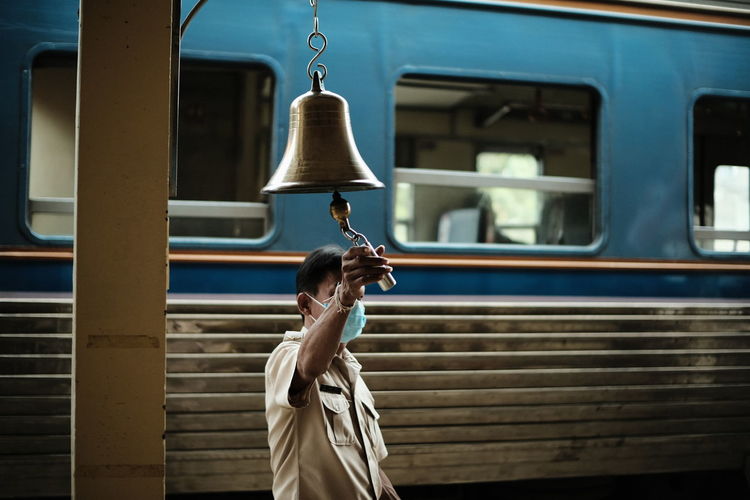 Man ringing bell at railroad platform