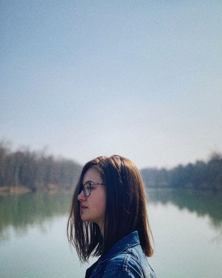 Portrait of woman against lake against clear sky