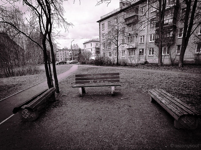 Empty bench in park by building