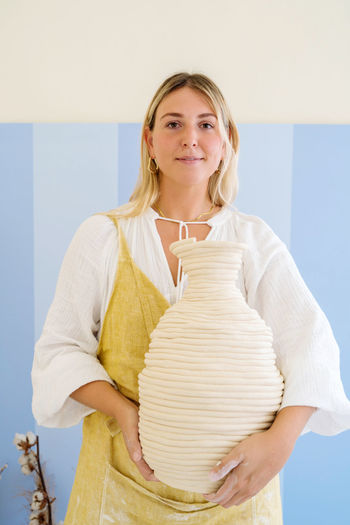 Woman pottery artist holding her handmade vase