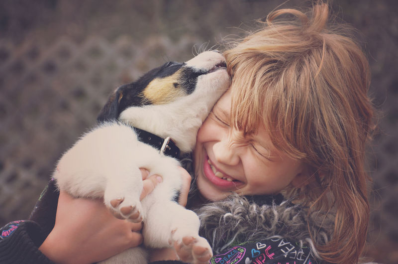 Close-up of girl with puppy in back yard