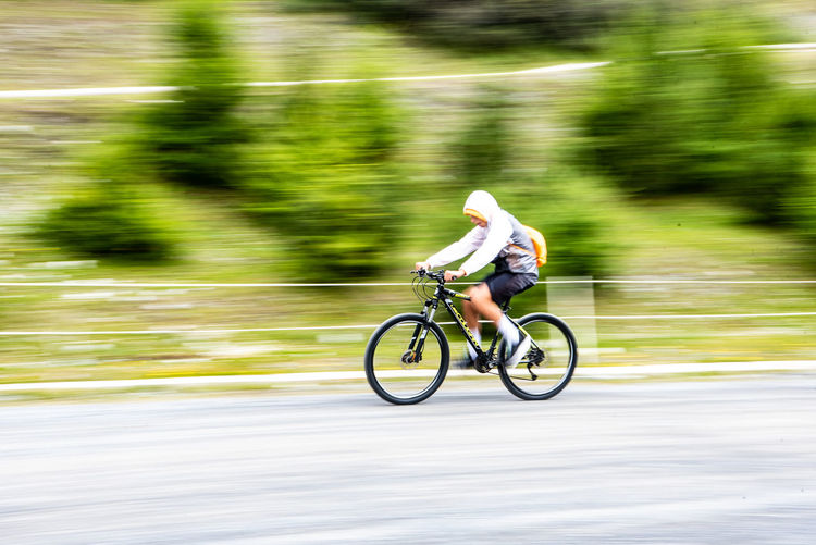 Teenage boy riding bicycle on road