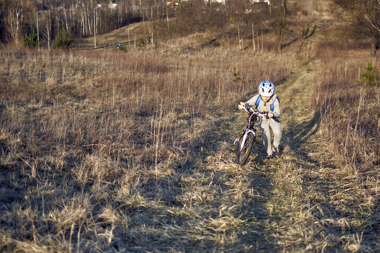 Boy riding bicycle on field