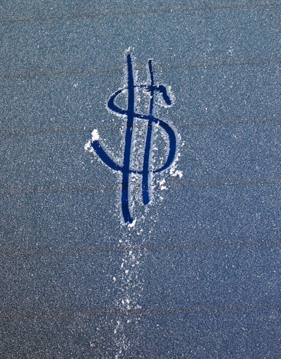 High angle view of dollar sign on frozen surface