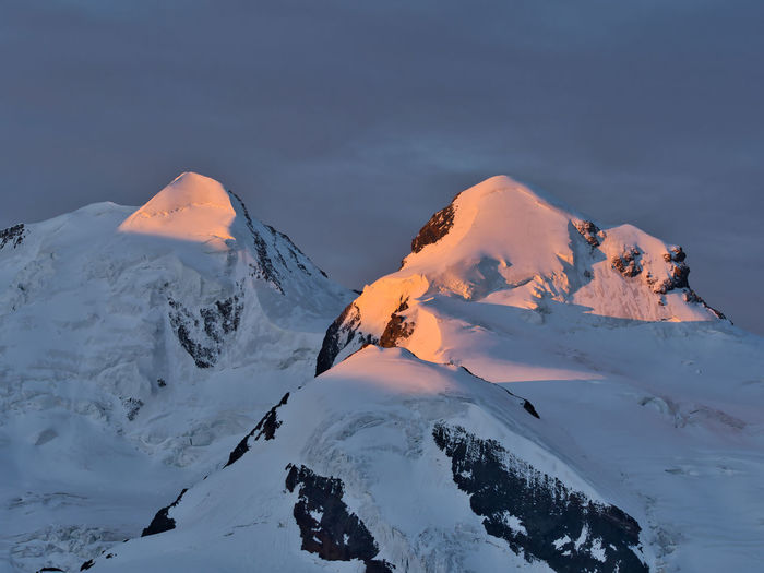 Scenic view of snowcapped mountain against sky at sunrise 