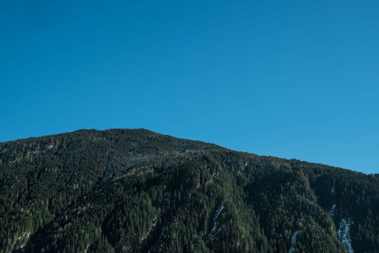 Low angle view of mountain against clear blue sky