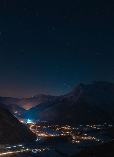 Scenic view of illuminated mountains against sky at night