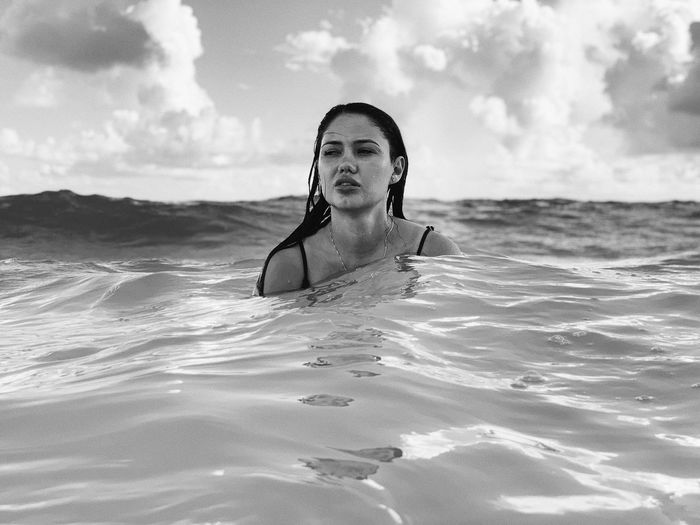 Woman looking away while swimming in sea