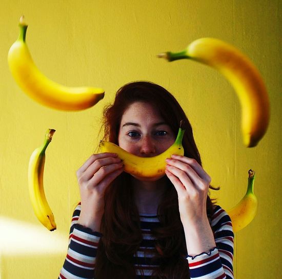 Portrait of beautiful young woman with bananas