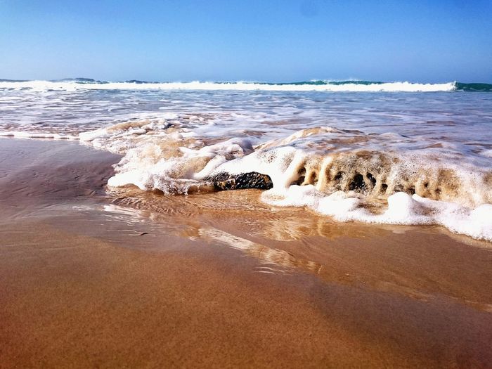 Waves rushing towards shore at beach