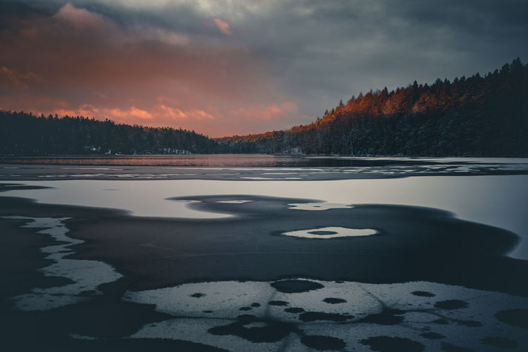 Scenic view of frozen lake against sky during sunset