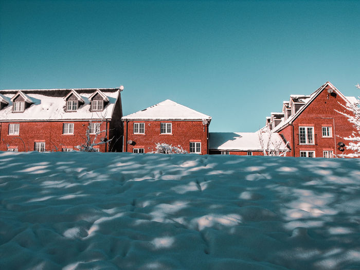 Houses in city against clear sky during winter