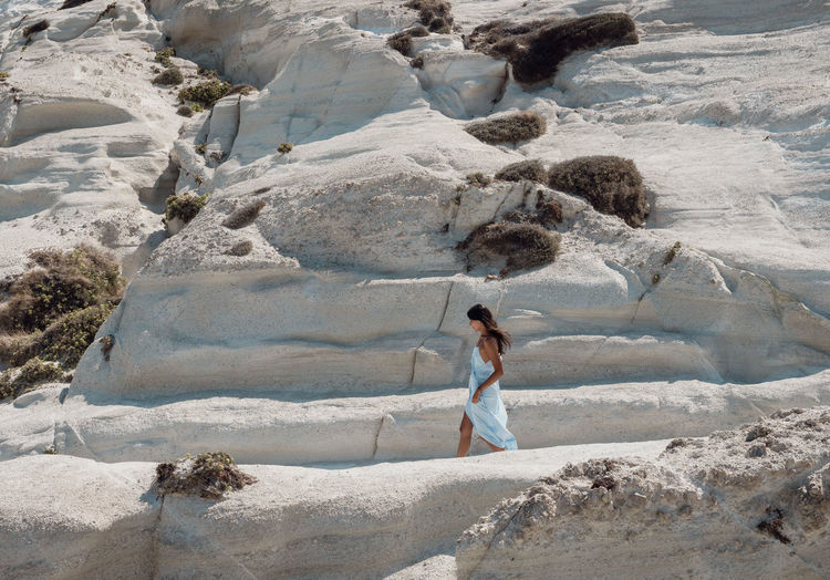 Side view of woman standing on rock