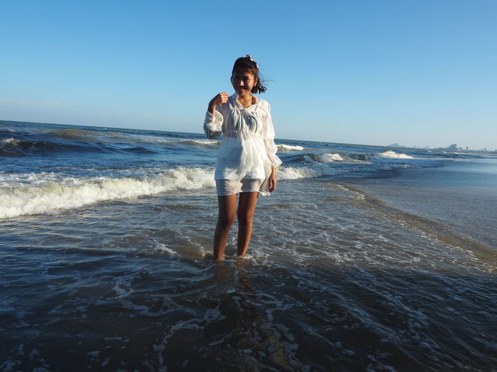 Full length of woman on beach against clear sky