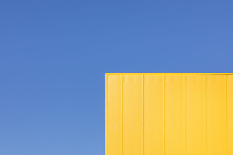 Low angle view of yellow cargo container against sky