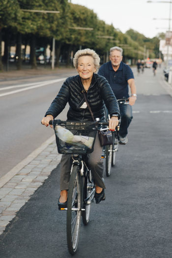 Portrait of woman riding bicycle on road in city