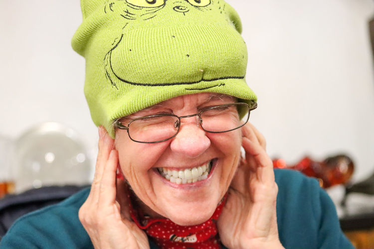 Happy baby boomer with grinch hat.