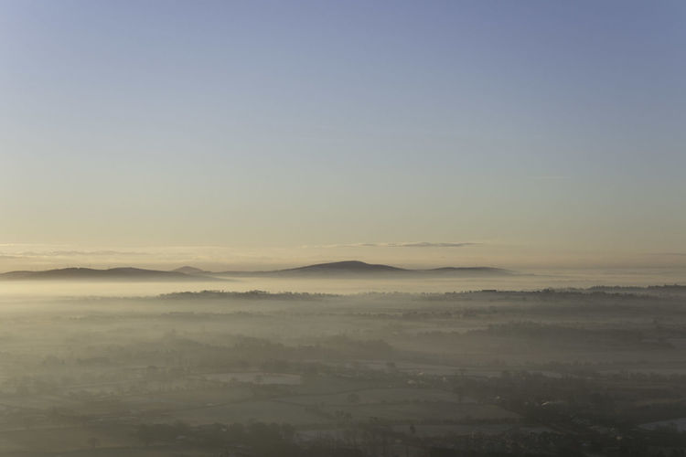 View from above of low lying thin layer of mist in dawn light