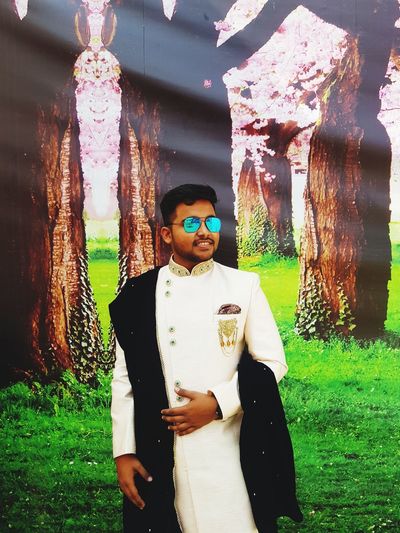 Digital composite image of man wearing sunglasses standing on field