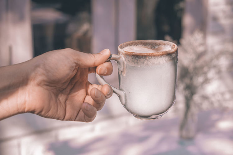 Close-up of hand holding drink coffee cup