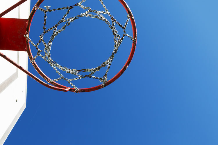 Directly below shot of basketball hoop against clear blue sky