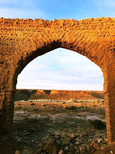 Landscape seen through arch bridge against sky