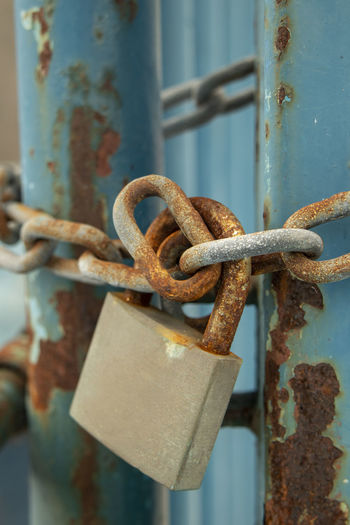 Close-up of rusty padlock on metal gate