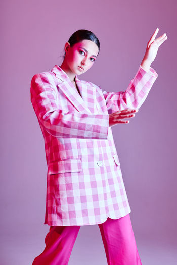 portrait of young woman standing against wall
