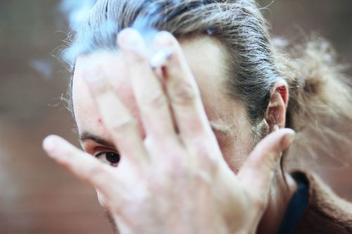 Close-up portrait of man holding cigarette