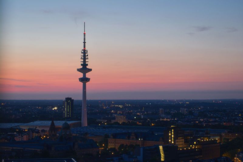 Illuminated buildings in city during sunset